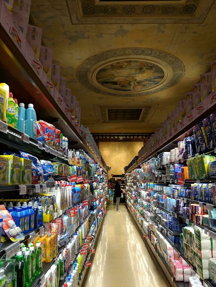 Pasillo de supermercado en un edificio con techo artístico, una sorpresa común para viajeros en otros países.