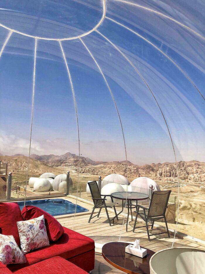 Interior de burbuja transparente con mobiliario moderno y vistas sorprendentes para viajeros en otros países.