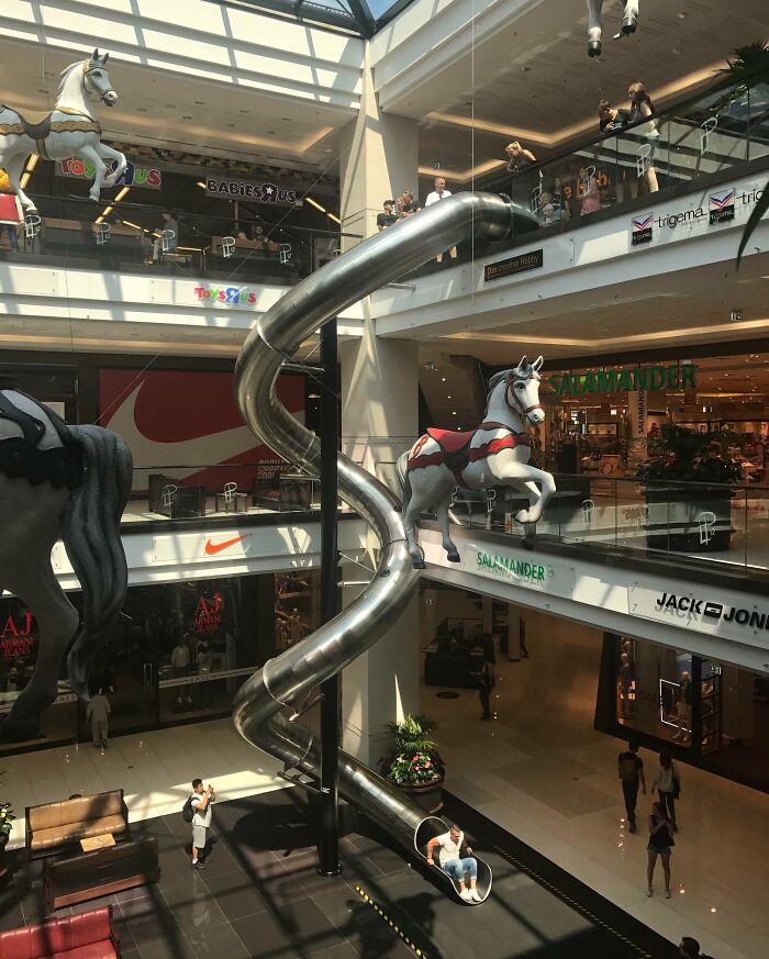 Tobogán metálico en centro comercial con figuras de caballos, una de las cosas que sorprendieron a los viajeros en otros países.
