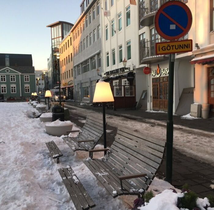 Bancos con lámparas encendidas en una calle nevada, una sorpresa común para viajeros en otros países.