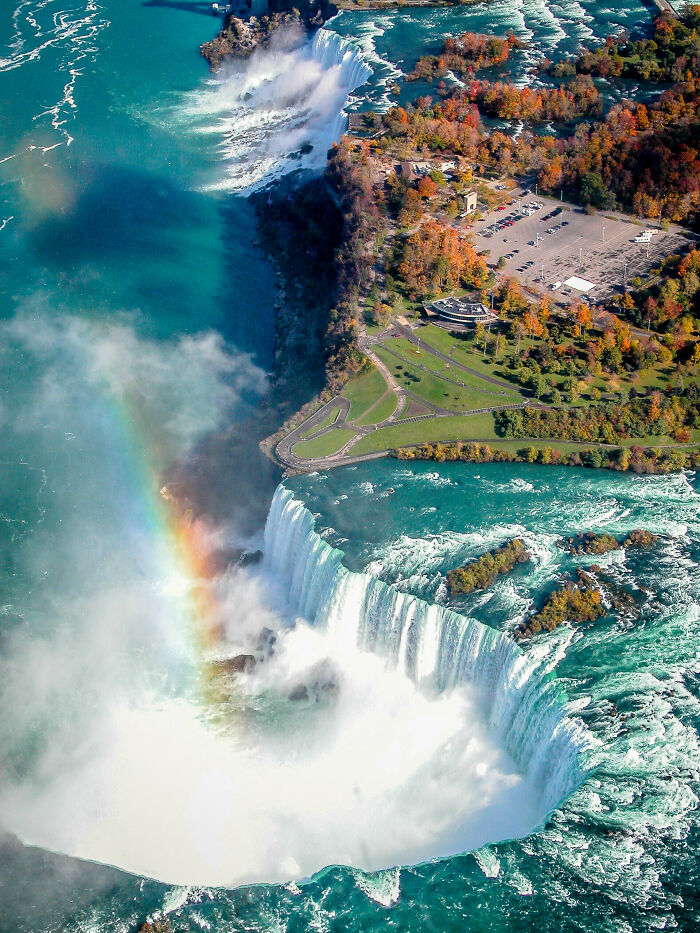 Cataratas de Canadá desde el aire con un arcoíris, rodeadas de vegetación y aguas cristalinas.