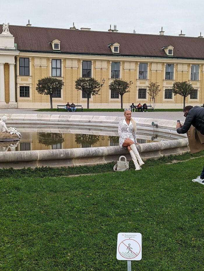 "Influencer posando junto a fuente ignorando señales de advertencia."