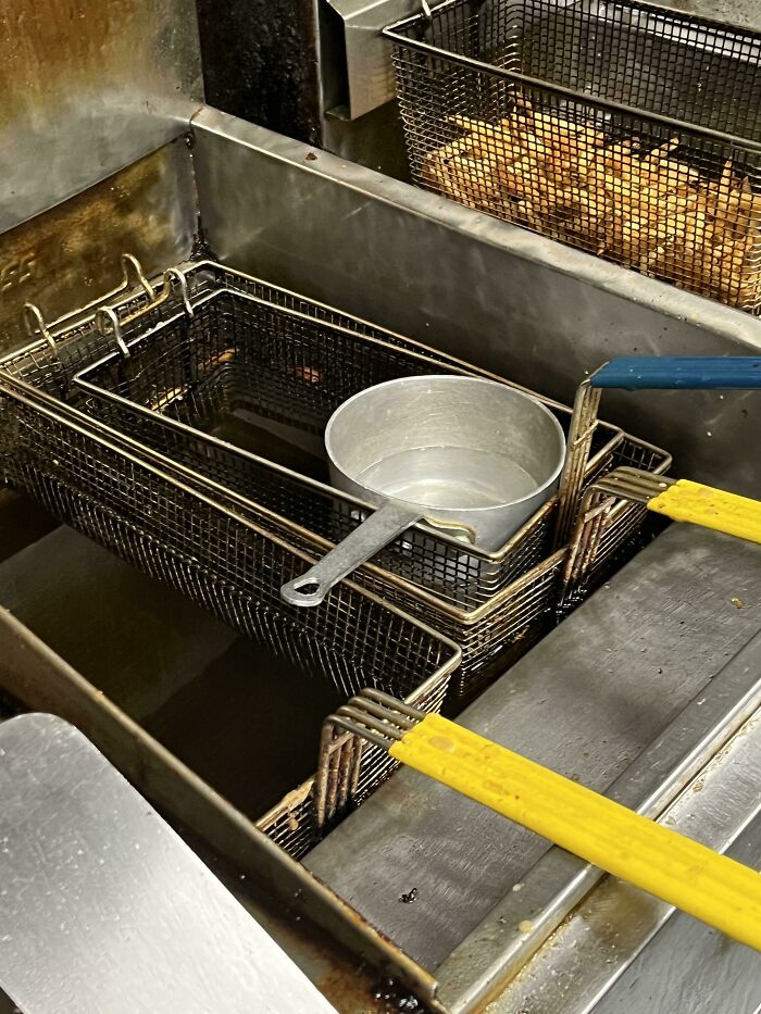 Freidora de cocina industrial con cestas usadas, típica en hostelería.