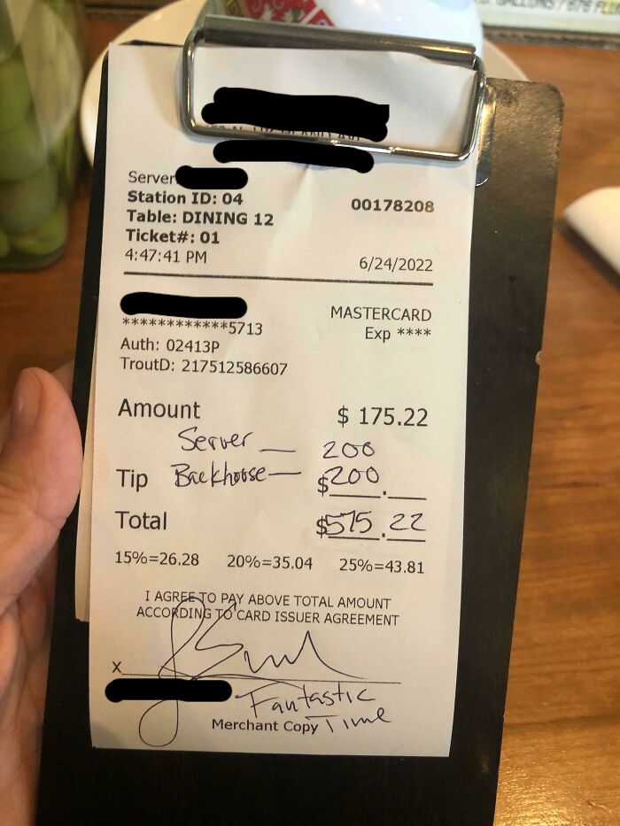 Factura de restaurante en la industria de hostelería mostrando alta propina escrita a mano en la cuenta.