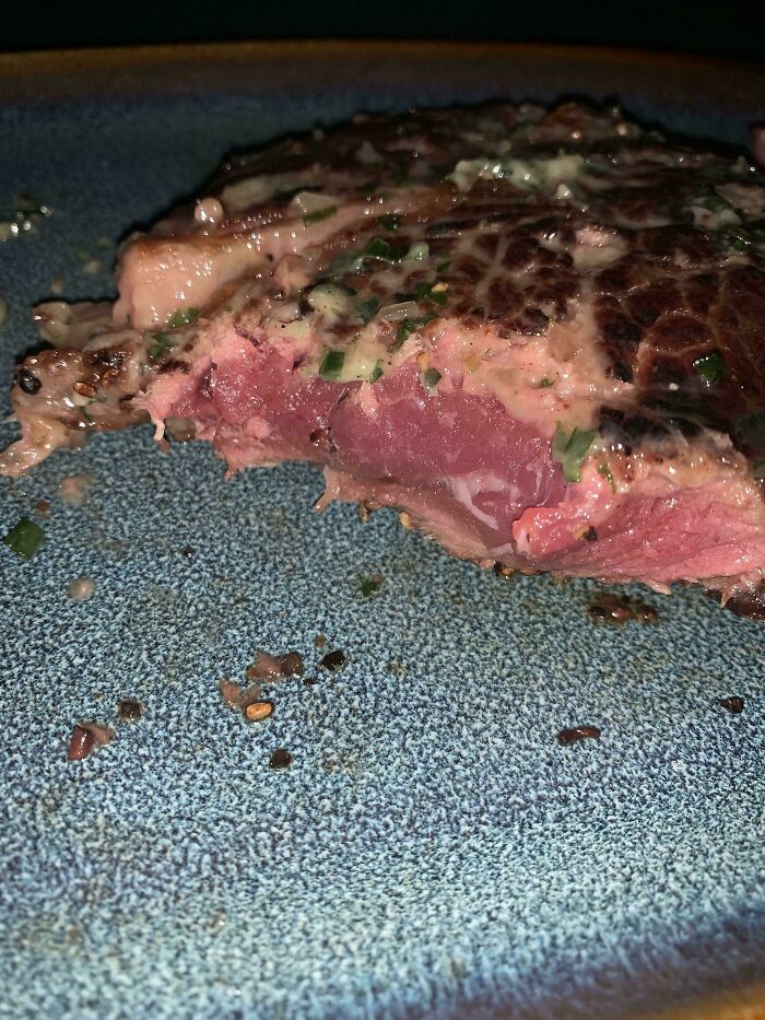 Carne parcialmente cruda en un plato azul, un desafío común en la industria de la hostelería.