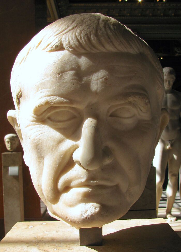 Busto de mármol iluminado en museo, representando curiosidades y datos sorprendentes para aprender hoy.