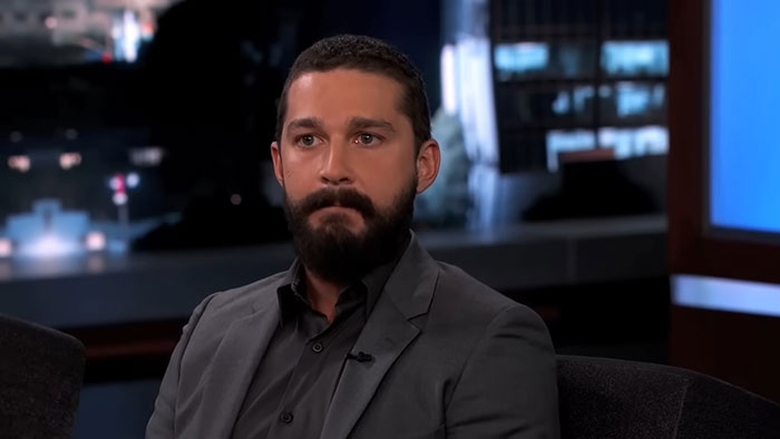 Un actor conocido participando en una entrevista nocturna, con una expresión seria.