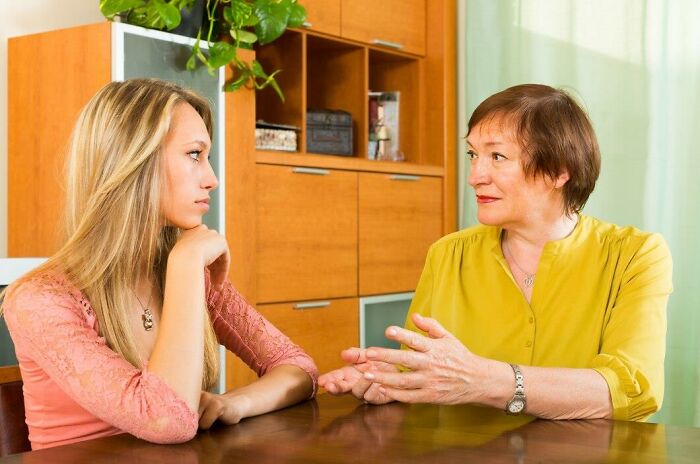 Dos mujeres conversando seriamente en una sala, representando estupideces que la gente dijo con toda seriedad.