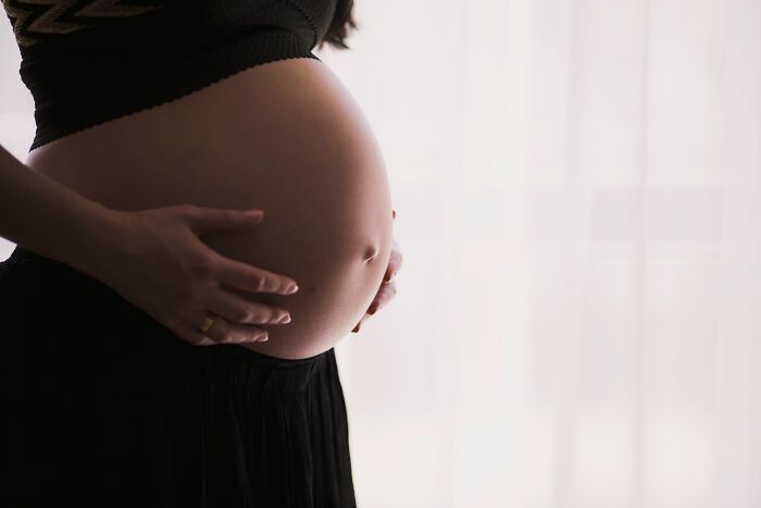 Mujer embarazada tocando suavemente su vientre, imagen que representa datos sorprendentes sobre conocimiento y aprendizaje.