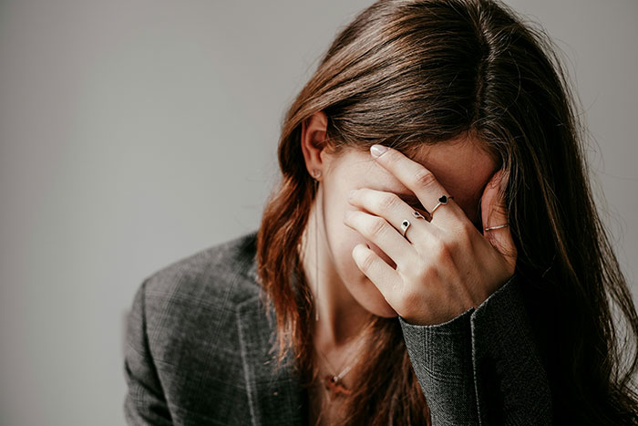 Mujer con gesto de desagrado, cubriéndose la cara; concepto de lo sexy que da asco en la vida real.