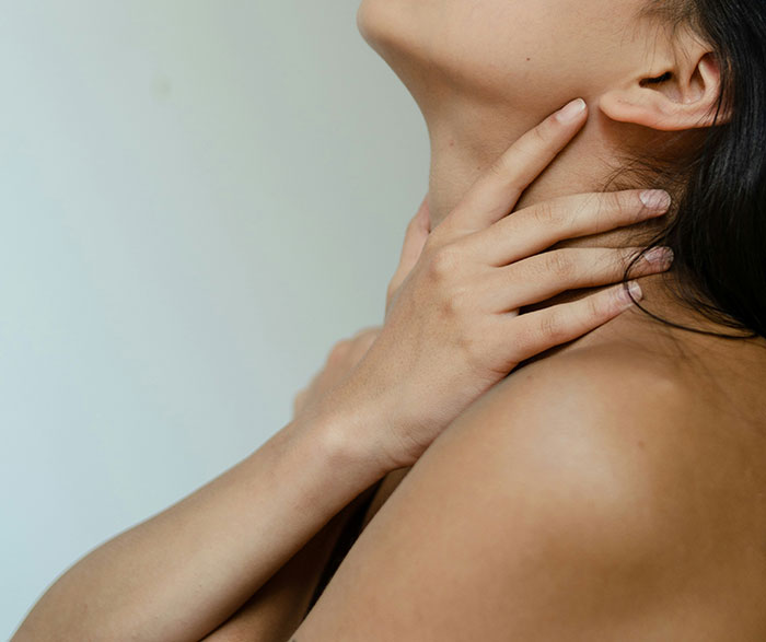 Persona tocando su cuello con elegancia, representando algo sexy en los libros pero distinto en la vida real.