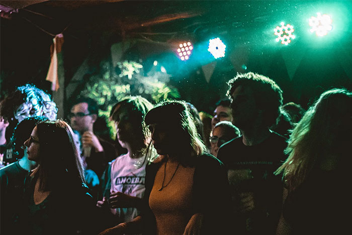 Grupo de personas en una fiesta iluminada, momento de urgencia para irse.