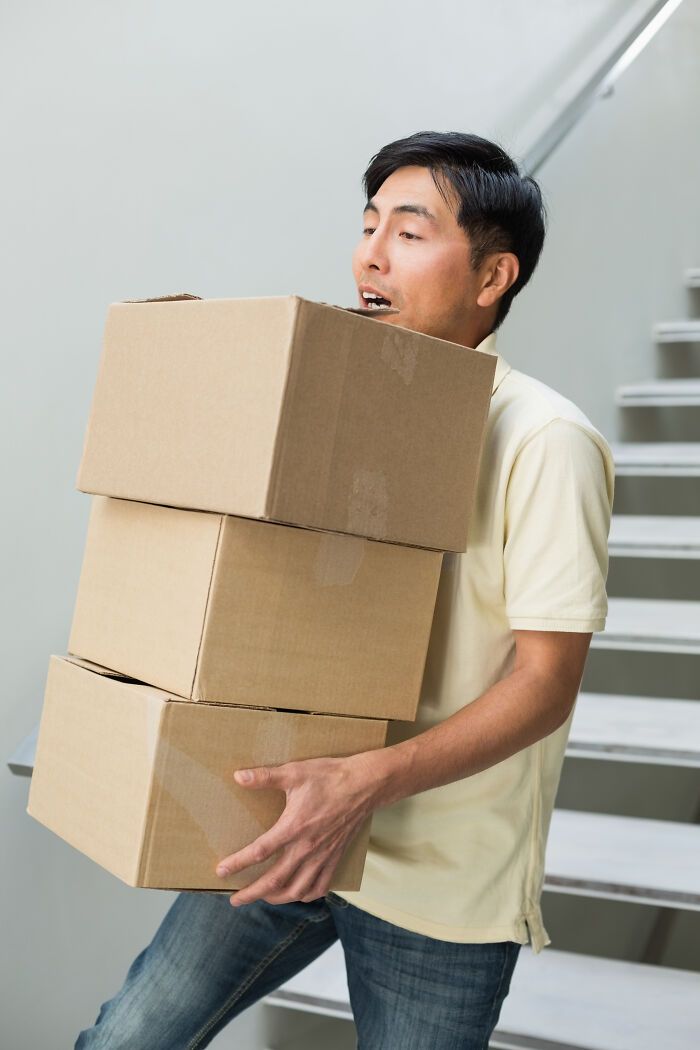 Hombre cargando tres cajas de cartón mientras sube escaleras, ilustrando datos sorprendentes y poco conocidos.
