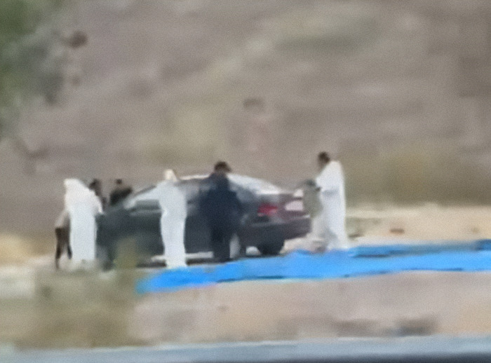 Investigadores en el sitio turístico mexicano investigan la desaparición de estudiantes, junto a un auto, usando trajes protectores.