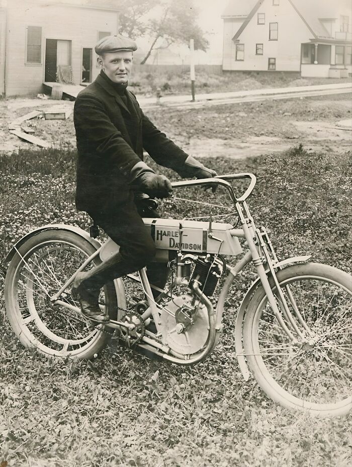 Persona con chaqueta y gorra en una antigua motocicleta Harley-Davidson, evocando días pasados.