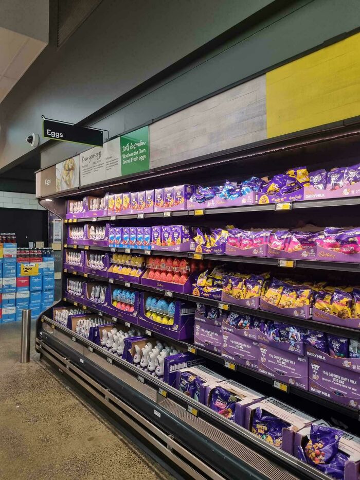 Estantería en tienda australiana con productos de Pascua bajo el letrero de huevos.