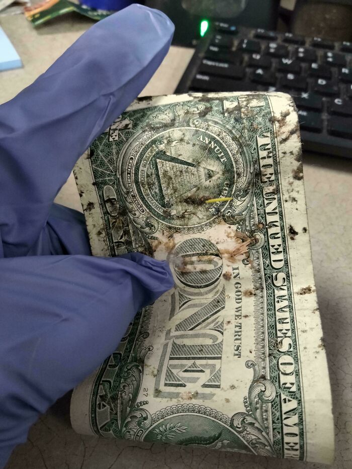 Mano con guante sosteniendo un billete sucio y dañado, ilustrando clientes ignorantes y frustrantes en trabajo.