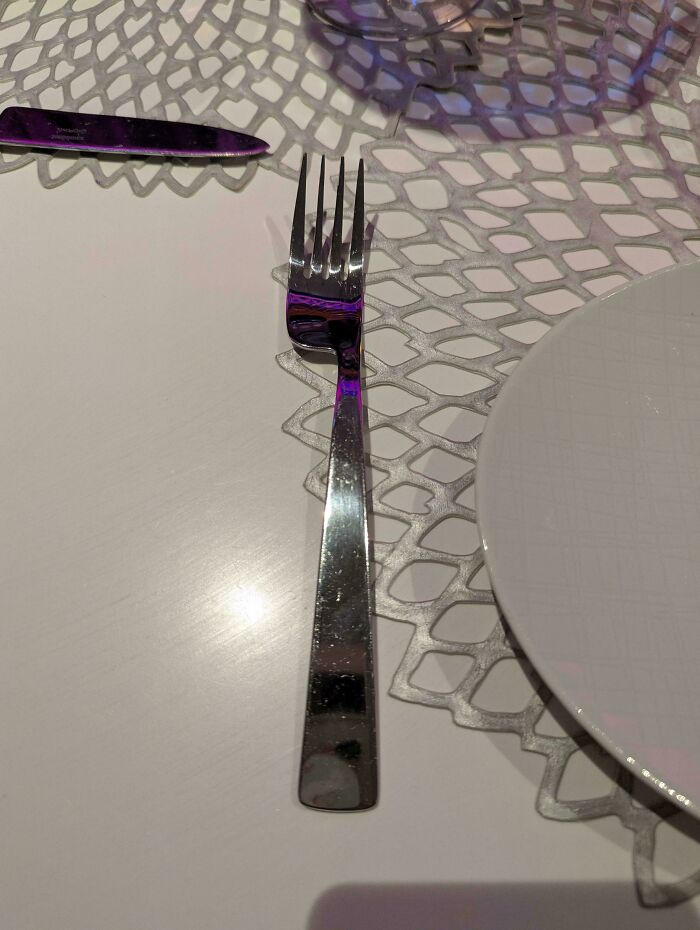 Tenedor colocado incorrectamente en la mesa, contribuyendo a arruinar tu día con una imagen molesta.