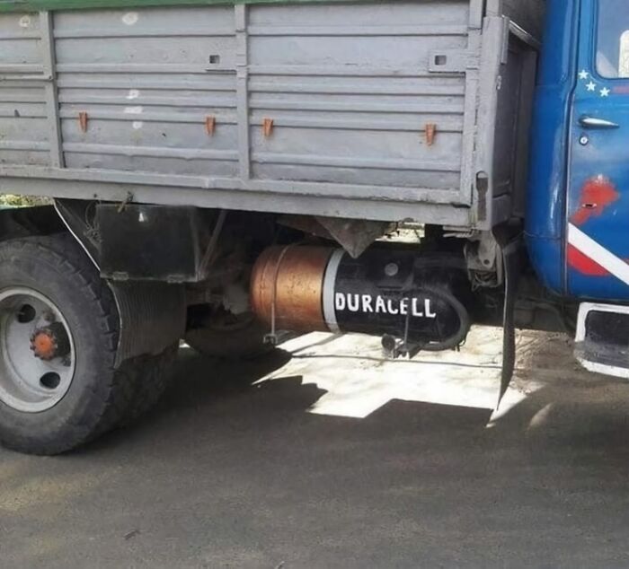 Camión con un tanque de combustible pintado como una pila Duracell, imagen rara y absurda.