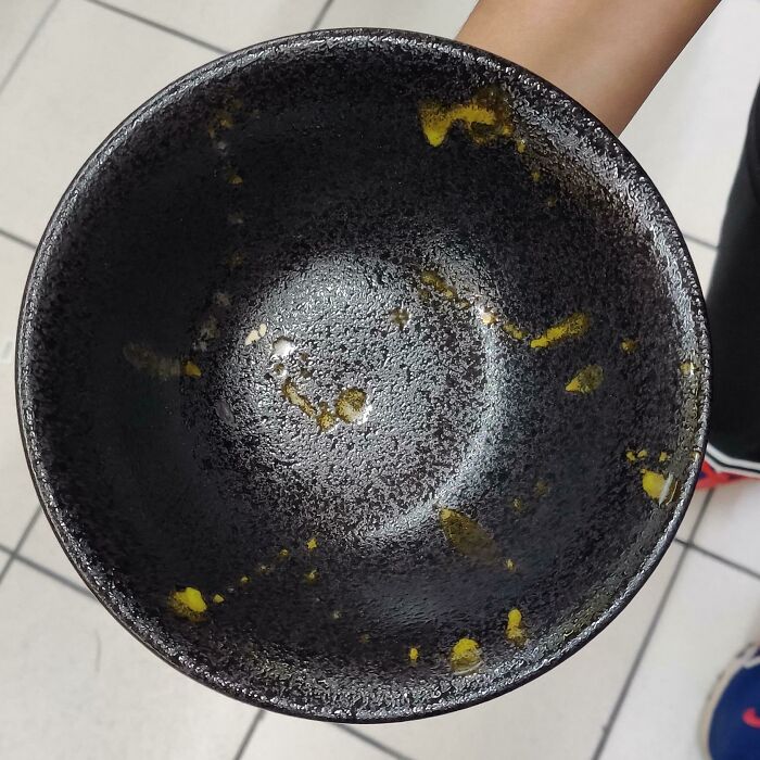 Cuenco negro con manchas amarillas, diseño que no funciona bien en la práctica.