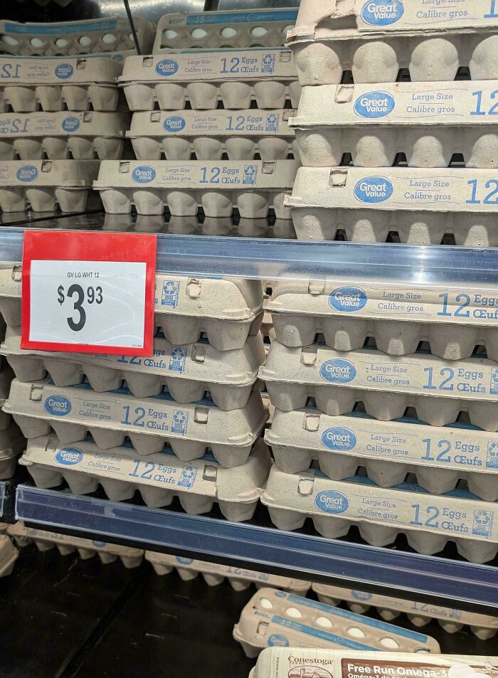 Cartones de huevos apilados con etiquetas de precio en un supermercado.
