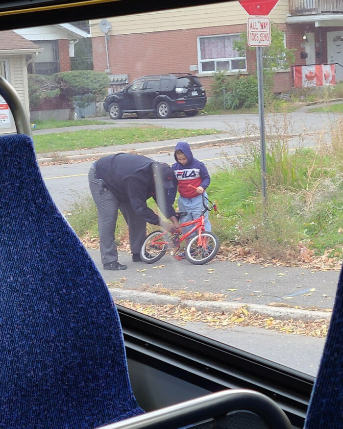 Padre ajustando la bici de su hijo en una acera, reflejando un típico momento en Canadá.