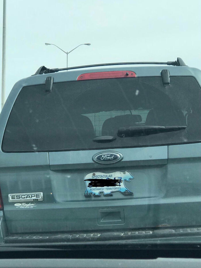 Automóvil en Canadá con placa en forma de oso que dice "Northwest Territories".