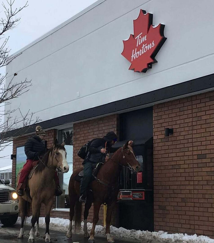 Dos personas a caballo en un autoservicio de Tim Hortons en Canadá.