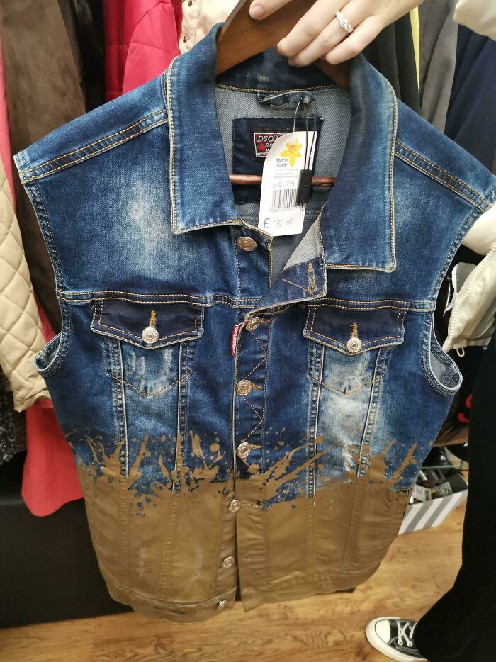 Chaleco de mezclilla con un diseño no funcional en la realidad, mostrando manchas marrones en la parte inferior.