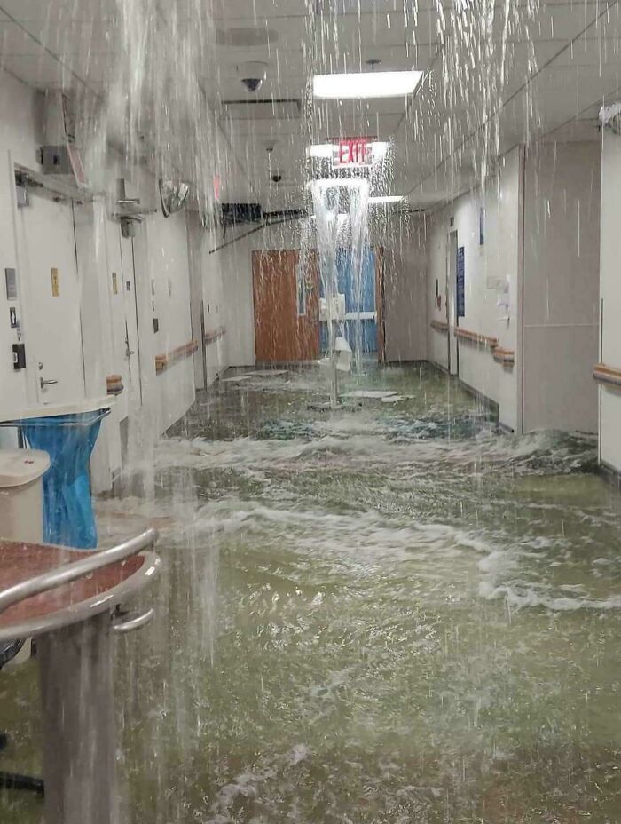 Pasillo inundado por un accidente costoso con agua cayendo del techo.