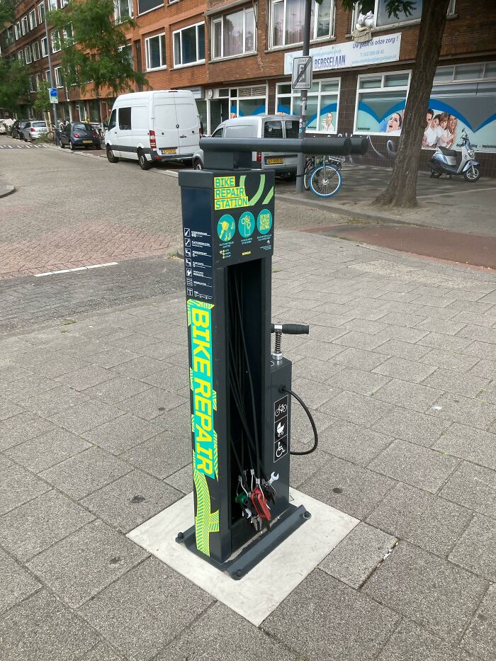 Estación de reparación de bicicletas en una calle, un detalle ingenioso integrado en la vida cotidiana de diversos países.