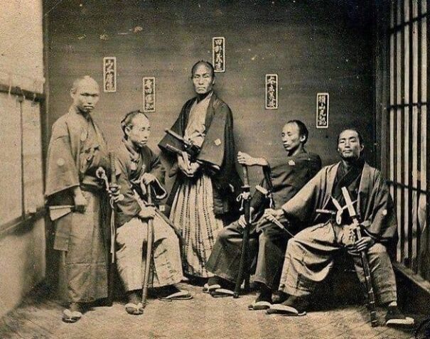 Guerreros samuráis posando con katanas, vistiendo atuendos tradicionales en una foto histórica poco conocida.