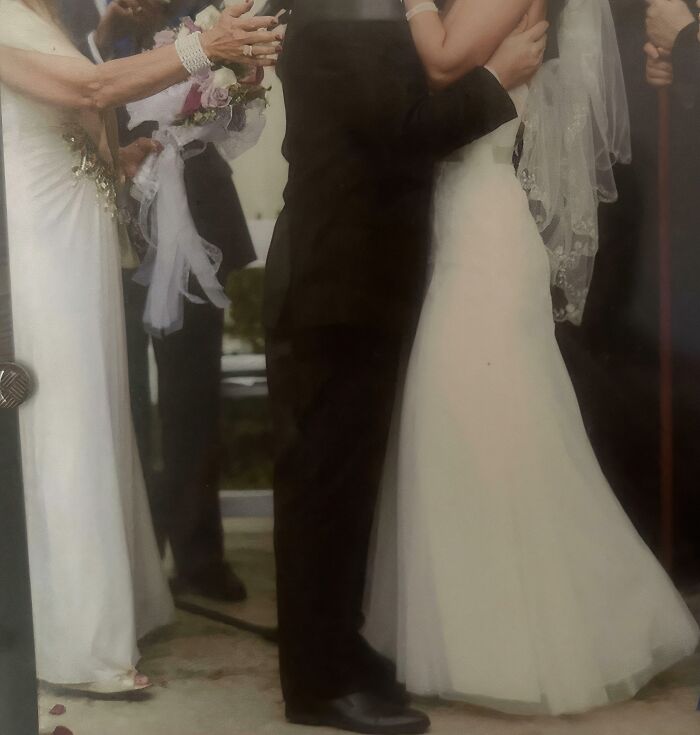 Una pareja en una boda con velo y traje, rodeados de invitados, en un momento memorable.