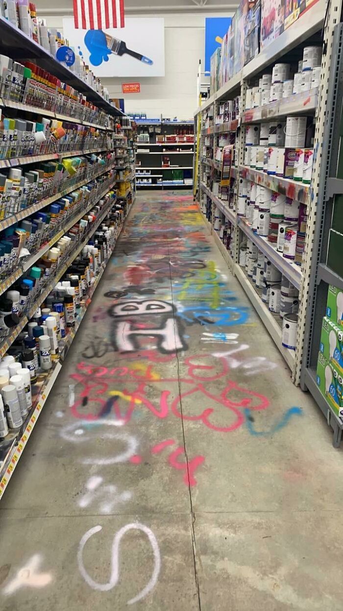 Pasillo de tienda con pinturas en aerosol y productos para pintar en estantes, ejemplo de clientes frustrantes y tontos.