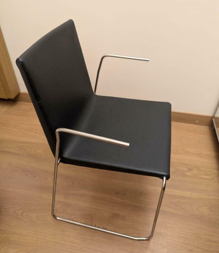 Una silla de diseño minimalista con brazos desalineados, mostrando cómo algunos diseños no funcionan en la realidad.