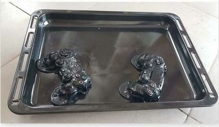 Mandos de consola derretidos en una bandeja de horno, representando un accidente caro.