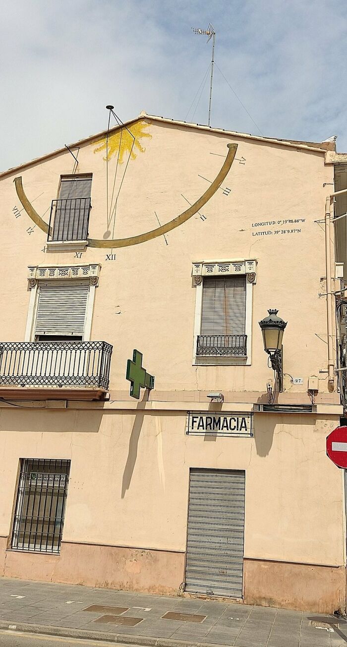 Reloj de sol en la pared de una farmacia, ejemplo de detalles ingeniosos en la vida cotidiana.