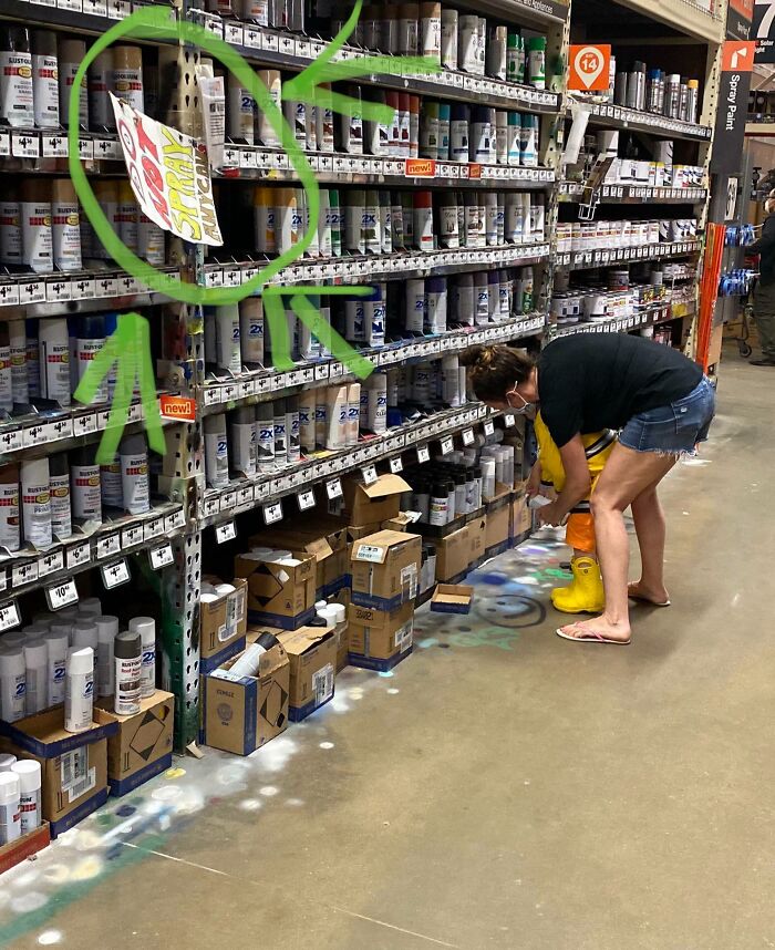Mujer con botas amarillas en tienda de pinturas, reflejando experiencias con clientes frustrantes e ignorantes en el trabajo.