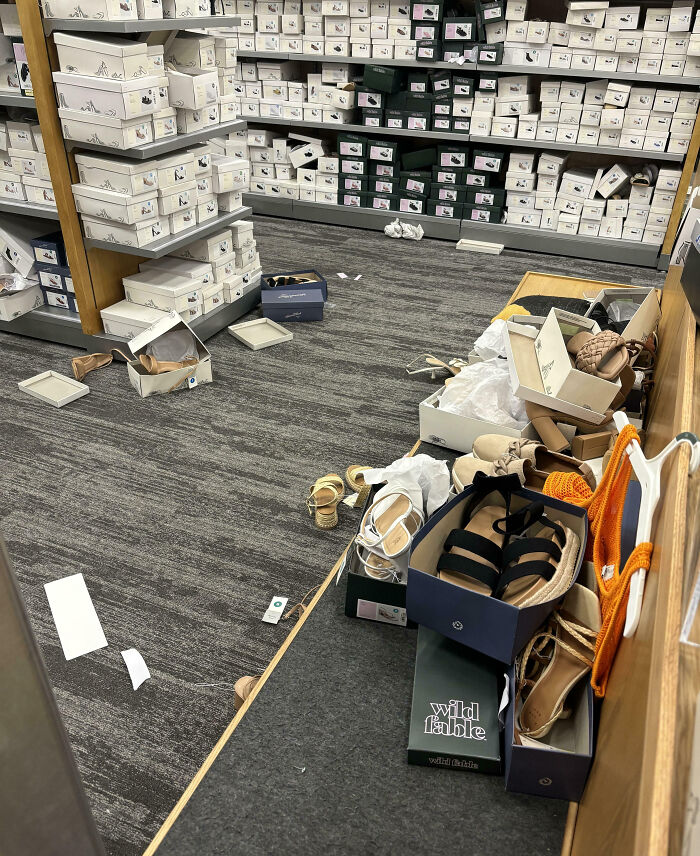 Tienda de zapatos desordenada con cajas abiertas y calzado fuera de lugar reflejando experiencia con clientes frustrantes.
