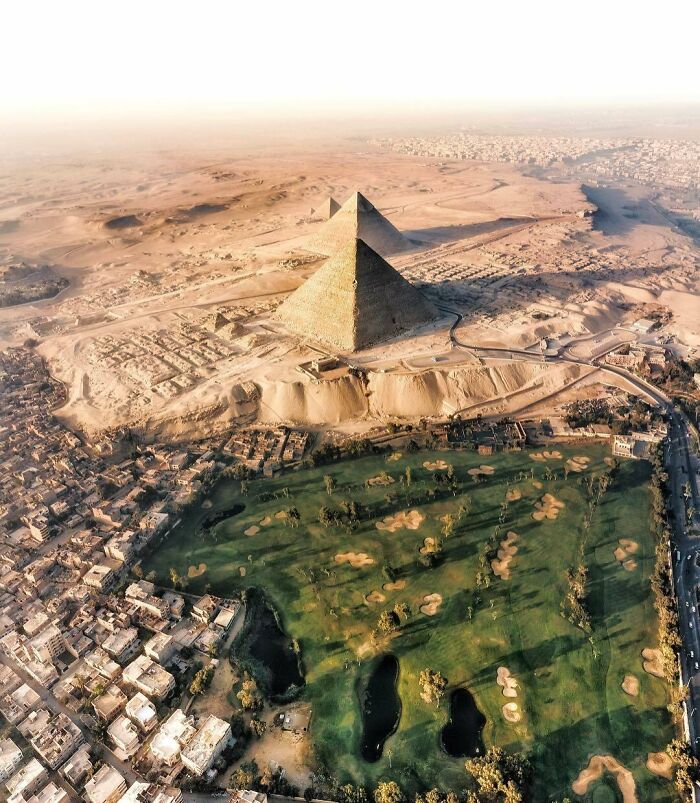 Vista aérea de las Pirámides de Egipto junto a un campo de golf, mostrando una perspectiva distinta.