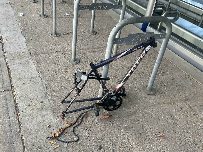 Bicicleta sin ruedas ni asiento en un aparcamiento, lo que sugiere un día de trabajo complicado.