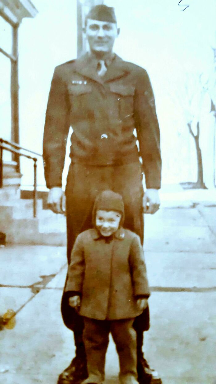 Hombre vestido de militar junto a un niño pequeño en una foto histórica fascinante en blanco y negro.