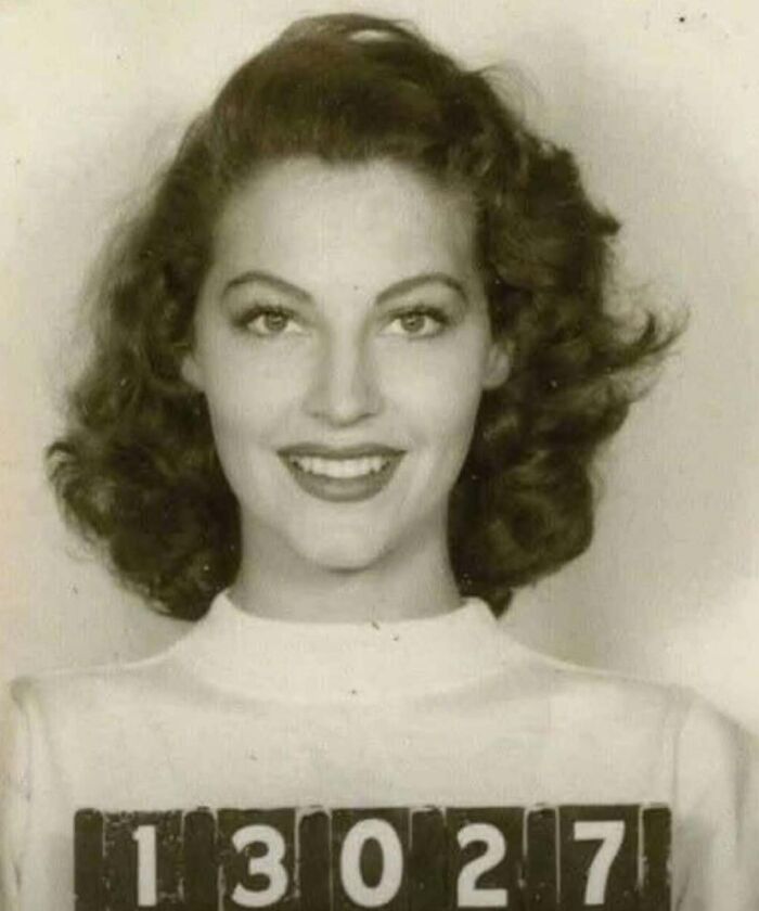 Mujer en una foto antigua, con el número de identificación 13027 y cabello rizado, simbolizando cambios históricos.