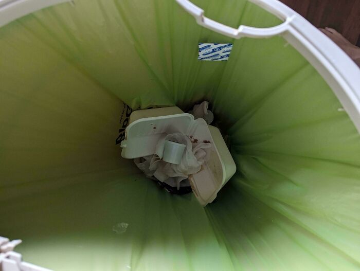 Contenedor de basura con restos desechados, representando la incomodidad con familia política.