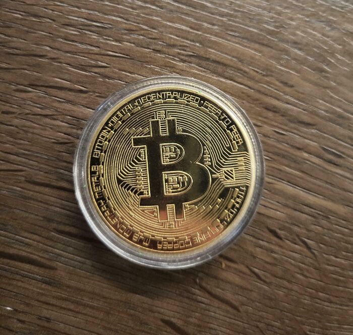 Moneda de bitcoin sobre una mesa de madera.