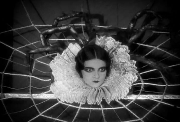 Rostro de mujer enredado en telaraña, imagen inquietante del pasado.