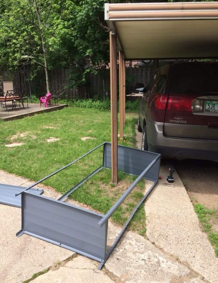 Cochera improvisada con estructura metálica caída junto a un auto estacionado, resaltando errores compartidos en internet.