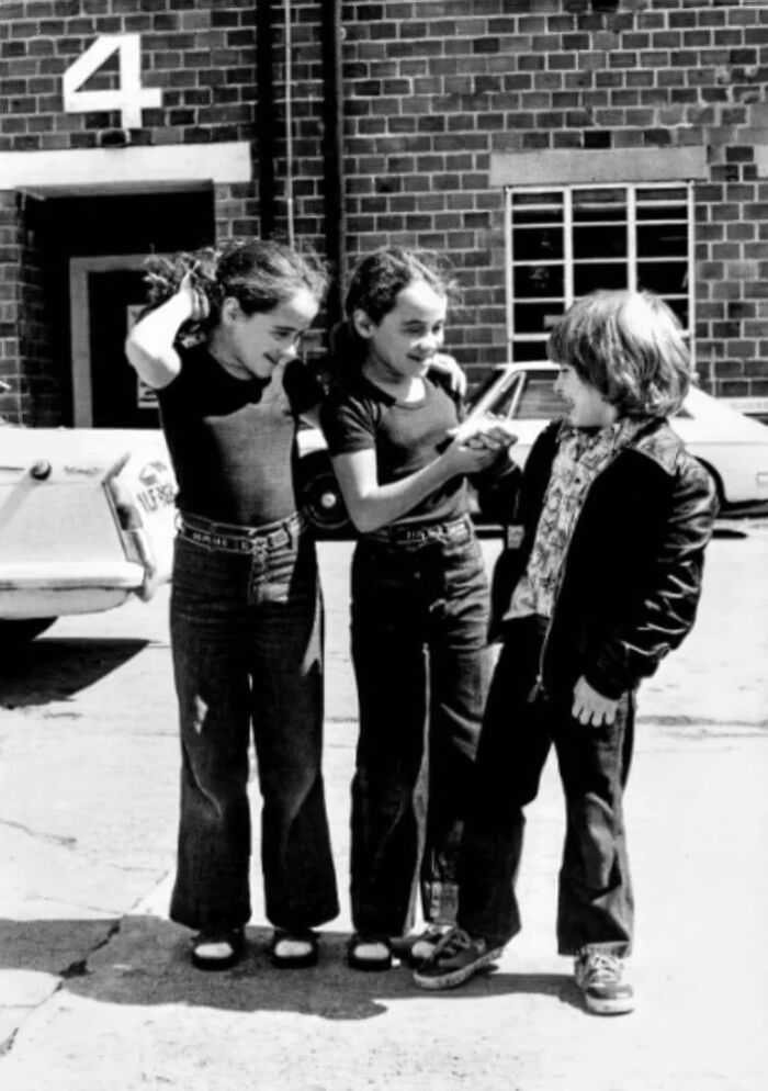Tres niños jugando en blanco y negro, imagen del pasado con ambiente inquietante.