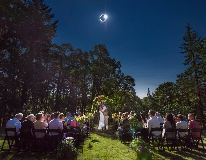 Boda al aire libre con eclipse solar de fondo; momento increíble capturado.