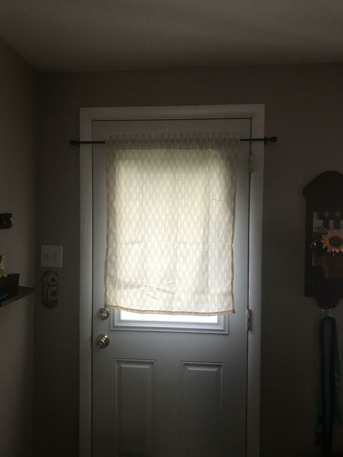 Cortina improvisada en una puerta, mostrando un intento de reparación que empeora la estética del hogar.